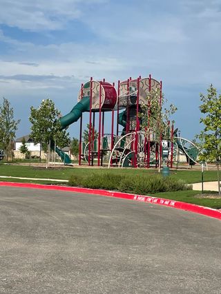 A vibrant playground with tall slides and climbing structures in Hennersby Hollow by Starlight Homes (San Antonio, TX).