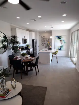 Model Home Modern kitchen with sleek white cabinets, elegant dining setup, and chic decor, offering a bright, airy atmosphere.