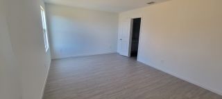 Model Home A bright room with light wood floors, minimalist design, and ample natural light through a single window.