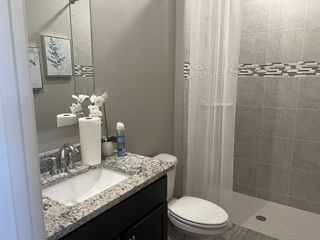 A sleek bathroom with a granite countertop, modern fixtures, and elegant tile accents.