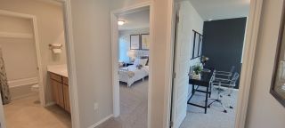 A modern hallway connects a chic bathroom, cozy bedroom, and sleek study, creating a harmonious and functional living space.