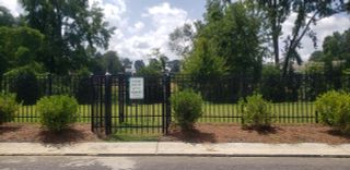 A serene, gated dog park with lush greenery in Chestnut Grove by Starlight Homes (Douglasville, GA).