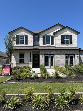 Elegant home with black shutters and a manicured yard in Massey Oaks by CastleRock Communities (Pearland, TX).