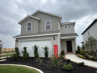 Charming gray home with a welcoming walkway and lush landscaping in Meadows at Clear Springs by Centex (New Braunfels, TX).