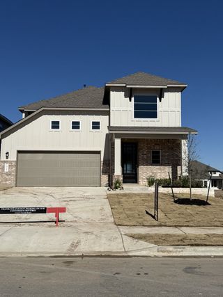 A modern two-story home with a garage and landscaped yard in Santa Rita Ranch by Scott Felder Homes (Liberty Hill, TX).