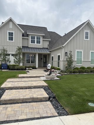 A charming gray and white home with manicured landscaping in Solterra Texas by Shaddock Homes (Mesquite, TX).