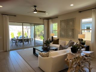Modern living area with sleek furniture, large windows, and an open view to a stylish outdoor patio.