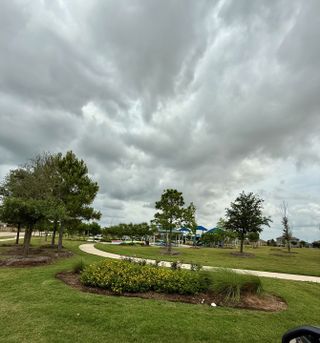 A scenic park with walking paths and lush greenery in Freeman Ranch by LGI Homes (Katy, TX).
