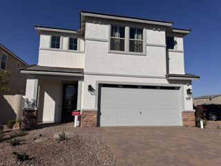 A modern white stucco home with stone accents and a spacious driveway in Bethany Grove by Beazer Homes (Glendale, AZ).