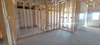 A home under construction with exposed framing and open layout, showcasing future potential.