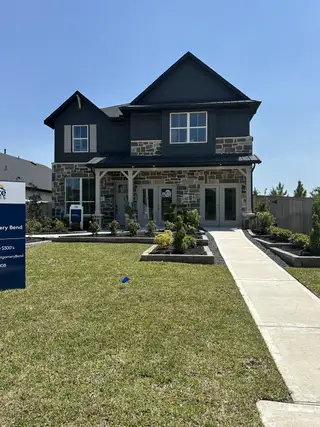 Street view A charming two-story home with stone detail and lush landscaping in Montgomery Bend by Pulte Homes (Montgomery, TX).