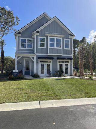 Street view A charming gray two-story home with manicured landscaping in Park's Edge at Carolina Bay by Pulte Homes (Charleston, SC).
