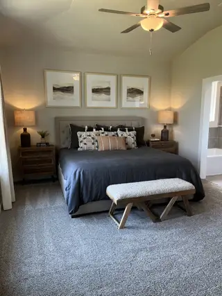 A cozy bedroom featuring a plush bed, wooden nightstands, elegant wall art, and soft lighting, perfect for relaxation.