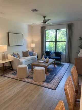 A cozy living room with a plush sofa, stylish rug, modern decor, and large window allowing natural light to fill the space.