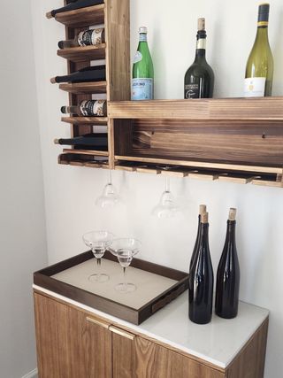 A stylish home bar with wooden wine racks, elegant shelving, and sleek glassware for a modern touch.