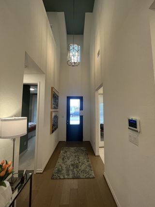 Model Home A soaring entryway with a dark accent ceiling, modern chandelier, and hardwood floors welcomes you into this residence.