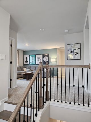 A cozy living space with plush carpet, modern railing, and stylish artwork for a contemporary feel.