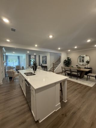 A spacious open-concept kitchen and dining area with a sleek island, warm wood floors, and stylish contemporary decor.