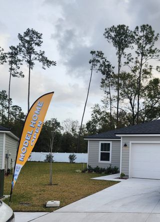 Street view A charming model home surrounded by tall trees in Walker’s Ridge – Phase II by Breeze Homes (Jacksonville, FL).