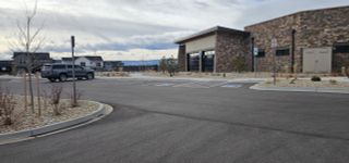 Modern stone building with a spacious parking lot in Montaine by Brightland Homes, Castle Rock, CO.
