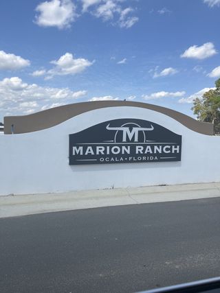 A prominent entrance sign for Marion Ranch by Lennar in Ocala, Florida, features a stylized "M" logo and bold lettering against a clean white and brown backdrop.