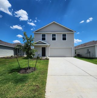 A modern two-story home with a spacious driveway and manicured lawn in Rancho Del Cielo by Lennar (Jarrell, TX).
