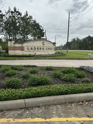 Street view Charming entrance sign with lush landscaping in Ladera Creek by Lennar in Conroe, TX, welcoming you home.