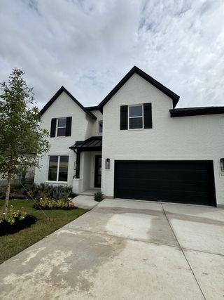 Street view A charming white brick home with black shutters in Nolina - 60' by Westin Homes, Georgetown, TX.
