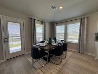 A bright dining area with a modern table, elegant place settings, and large windows offering plenty of natural light.