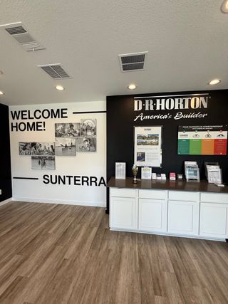 Street view A welcoming interior with warm wood floors, promotional materials, and a stylish design emphasizing Sunterra by D.R. Horton.