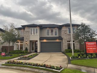 A stunning modern home with brick and stucco accents, lush landscaping, and a welcoming entry in Elyson 60s - Darling by Taylor Morrison in Katy.