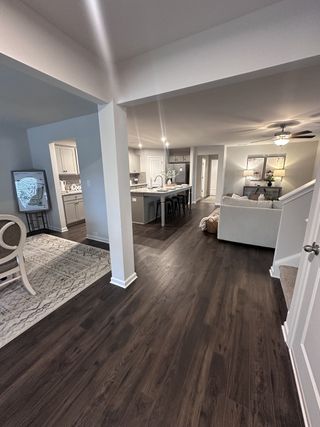 An elegant open-concept living space featuring dark wood floors, a modern kitchen, and cozy dining area.