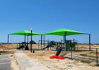 A vibrant playground with green shade canopies in Ocala Crossings South by D.R. Horton (Ocala, FL).