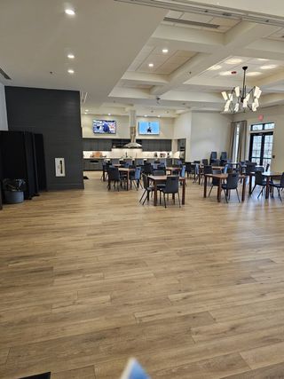 A modern dining space with high ceilings, warm lighting, and a spacious layout, ideal for social gatherings and community events.