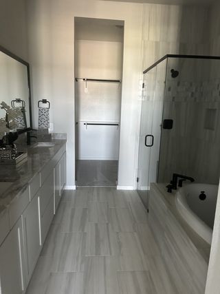 A modern bathroom with a sleek vanity, spacious shower, and elegant tiling, offering a serene retreat.