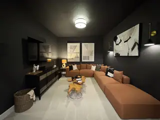 A cozy media room featuring a plush sectional sofa, modern wall art, and ambient lighting for a relaxing atmosphere.