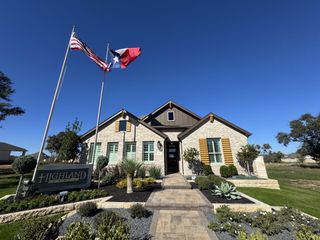 Street view A beautifully designed Highland Homes residence in La Cima, San Marcos, TX, with elegant stone accents and meticulous landscaping.