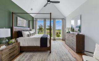 Model Home A serene bedroom featuring a four-poster bed, nature views, and elegant decor in soothing tones.