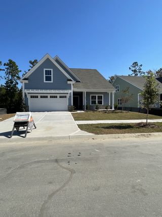 A charming blue home with a two-car garage and manicured lawn in North Creek at Nexton by True Homes (Summerville, SC).