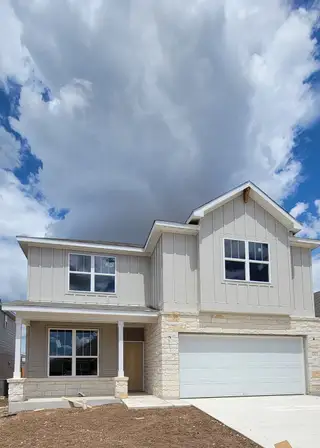 A charming beige two-story home with a spacious garage in Cinco Lakes by Centex, San Antonio, TX.