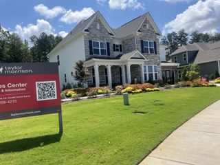 Street view A charming stone and siding home with lush landscaping in Estates at Sugar Creek by Taylor Morrison (Indian Land, SC).
