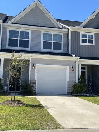 A charming gray townhouse with a manicured lawn in The Landings at Montague by Eastwood Homes (Goose Creek, SC).