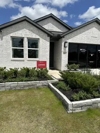 A modern white brick home with manicured landscaping in Raburn Reserve 50s by Taylor Morrison (Tomball, TX).