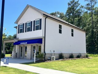 A modern white brick home with black shutters and a pristine yard in Millers Pointe by Lennar (Conyers, GA).