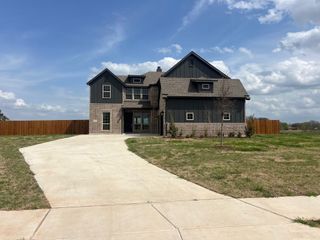 A modern dark-paneled and brick home with a spacious driveway in Crystal Lake Estates by Sumeer Homes (Red Oak, TX).