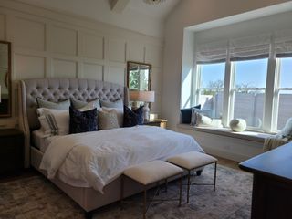 A serene bedroom with a tufted headboard, cozy bedding, and a sunlit window seat, perfect for relaxation.