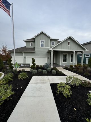Street view A modern green home with a landscaped yard in Whisper Valley by GFO Home (Manor, TX).