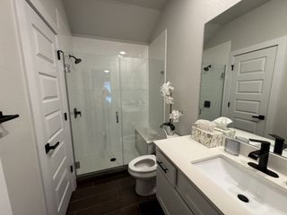Model Home A sleek bathroom featuring a glass-enclosed shower, modern fixtures, and a stylish vanity.