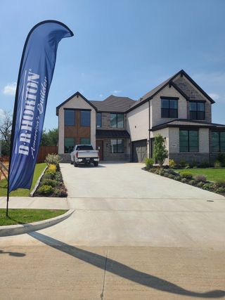 A beautiful modern home with a spacious driveway and manicured lawn in Northside Place by D.R. Horton (Carrollton, TX).