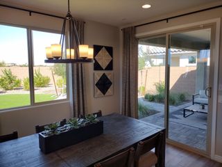 A modern dining area with a wooden table, succulent centerpiece, stylish chandelier, and patio access for seamless indoor-outdoor living.